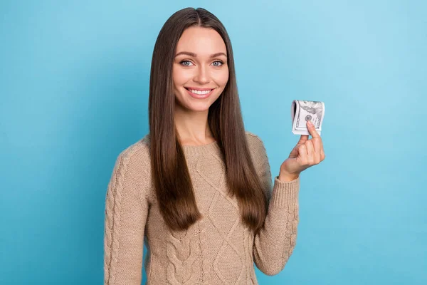 Retrato de atractiva chica de pelo castaño alegre sosteniendo en la mano el préstamo de crédito de ingresos de dinero aislado sobre fondo de color azul brillante — Foto de Stock