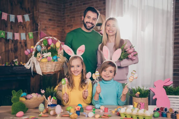 Fotografie plné rozkošné rodiny držet řemeslné malované vejce čerstvé tulipány květiny dům uvnitř — Stock fotografie