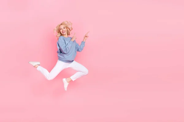 フルサイズ写真の若い陽気な女性プロモータージャンプ示す指空のスペースプロモーション選択絶縁上ピンク色背景 — ストック写真