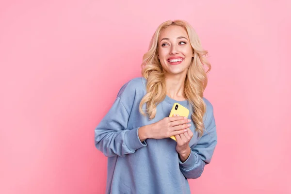 Foto van jong vrolijk meisje nieuwsgierig blik lege ruimte houden mobiele droom geïsoleerd over roze kleur achtergrond — Stockfoto