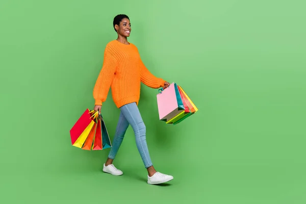 Volledige foto van zoete millennial guy gaan doen winkelen dragen trui jeans sneakers geïsoleerd op groene achtergrond — Stockfoto