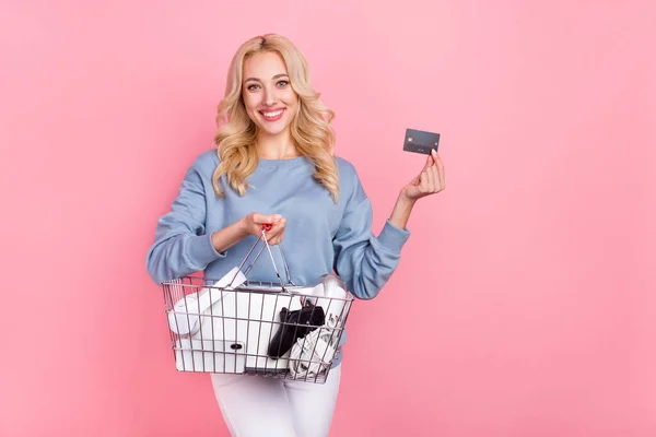 Фото молодой веселой девушки сделать покупки с помощью банковской карты доход пособие изолированы на розовом фоне — стоковое фото