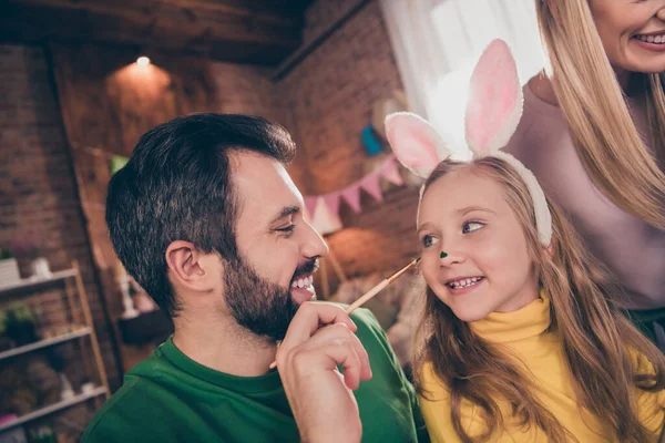 Portrét pozitivních přátelských rodičů dcera držet střapec barva nos baví nosit králičí čelenku uvnitř — Stock fotografie