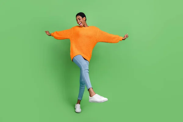 Corpo inteiro foto de bonito millennial morena senhora dança desgaste camisola jeans tênis isolado no fundo verde — Fotografia de Stock