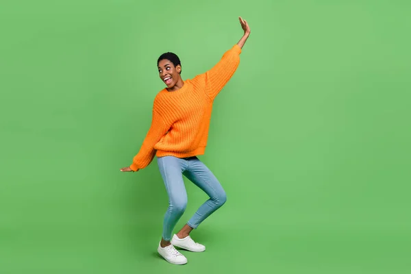 Corpo inteiro foto de fresco millennial morena senhora dança olhar promo desgaste camisola jeans sapatos isolados no fundo verde — Fotografia de Stock
