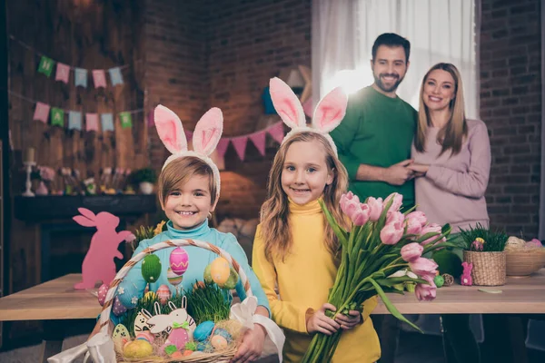 Fotografie plné idylické rodiny sourozenci držet velikonoční koš čerstvé květiny dárek dárek dárek dům uvnitř — Stock fotografie