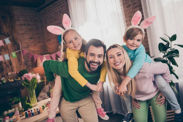 Portrét čtyř pozitivních radostných idylických lidí baví držet prasečí záda dětský dům uvnitř — Stock fotografie