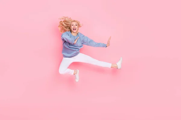 Full size foto van jong vrolijk meisje veel plezier spring omhoog vechter strijd geïsoleerd over roze kleur achtergrond — Stockfoto