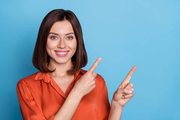 Photo of young cheerful lady indicate fingers empty space ads promo proposition isolated over blue color background — Stock Photo, Image