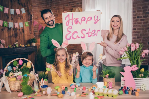 Portret w pełni pozytywnej rodziny trzymać szczęśliwy tabliczki wielkanocne sztandar nosić królicze uszy rękodzieło farby jaj wewnątrz — Zdjęcie stockowe