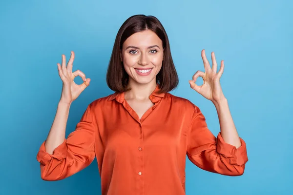 Retrato de menina conteúdo alegre atraente mostrando anúncio duplo ok-sinal isolado sobre fundo de cor azul brilhante — Fotografia de Stock