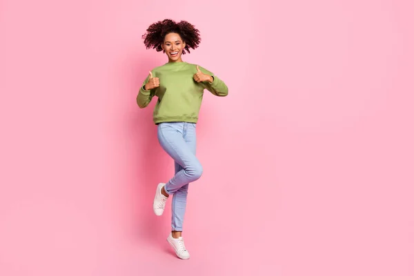 Volledige lengte foto van jong vrolijk meisje energetische sprong show vingers duimen-up feedback perfect geïsoleerd over roze kleur achtergrond — Stockfoto