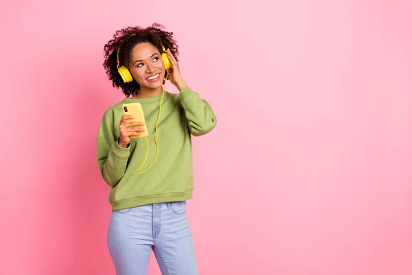Φωτογραφία του νεαρού χαρούμενο κορίτσι ακούσετε ραδιόφωνο μελωδία ακουστικά χρησιμοποιούν το κινητό εξετάσουμε κενό χώρο απομονώνονται σε ροζ φόντο χρώμα — Φωτογραφία Αρχείου