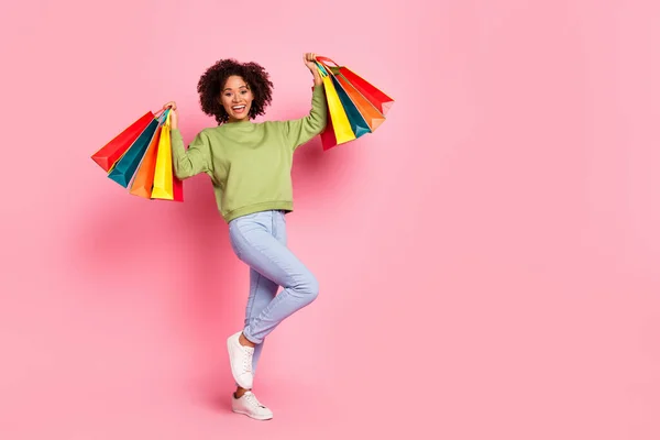 Full length foto van jonge vrolijke meisje hold tassen kopen huidige winkel promo geïsoleerd over roze kleur achtergrond — Stockfoto