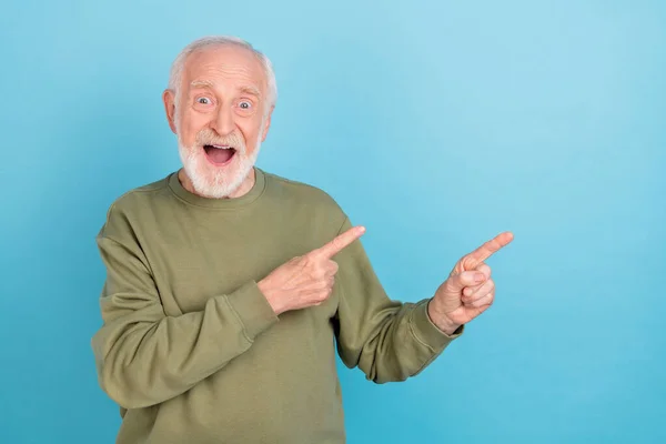 Portret van aantrekkelijke vrolijke trendy verbaasd grijs-harige man tonen kopieerruimte advertentie bieden geïsoleerd over helder blauwe kleur achtergrond — Stockfoto