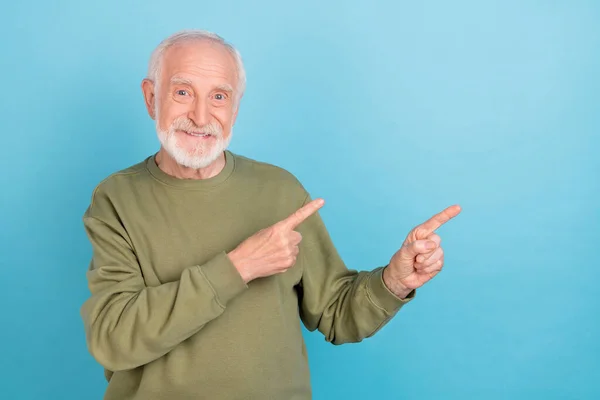 Portret van aantrekkelijke vrolijke grijs-harige man demonstreren kopieerruimte advertentie bieden geïsoleerd over helder blauwe kleur achtergrond — Stockfoto