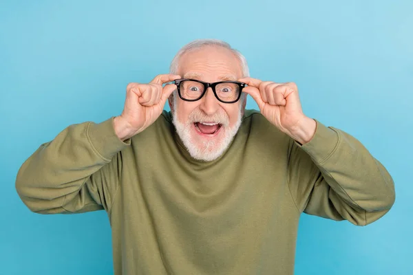 Retrato de atractivo loco alegre sorprendido hombre de pelo gris geek tocando especificaciones aisladas sobre fondo de color azul brillante —  Fotos de Stock