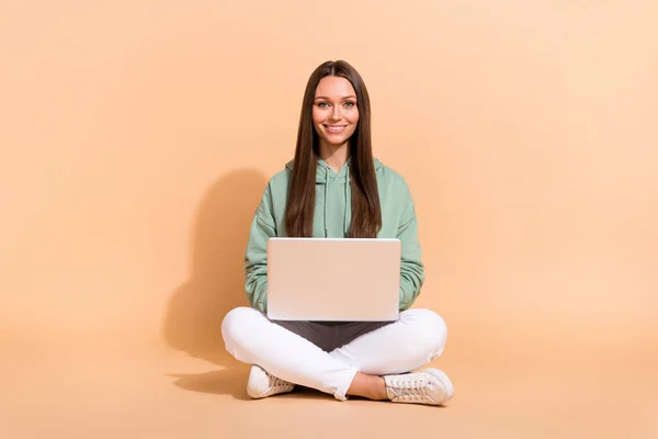 Ritratto di attraente allegra ragazza abile seduta utilizzando laptop scrittura lettera e-mail isolato su sfondo di colore pastello beige — Foto Stock