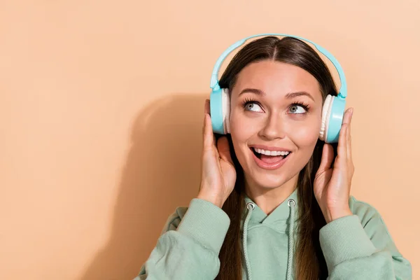 Porträtt av attraktiva glada drömmande brunhårig flicka lyssnar enda stereo kopia utrymme isolerad över beige pastell färg bakgrund — Stockfoto