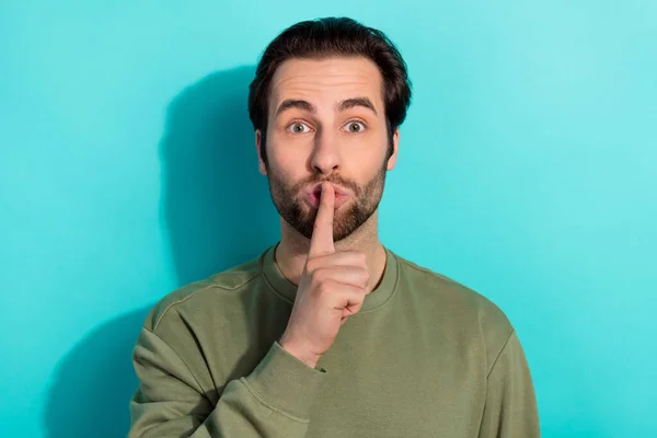 Fénykép a csendes szakáll fiatal srác ujj száj visel khaki pulóver elszigetelt kékeszöld háttér — Stock Fotó