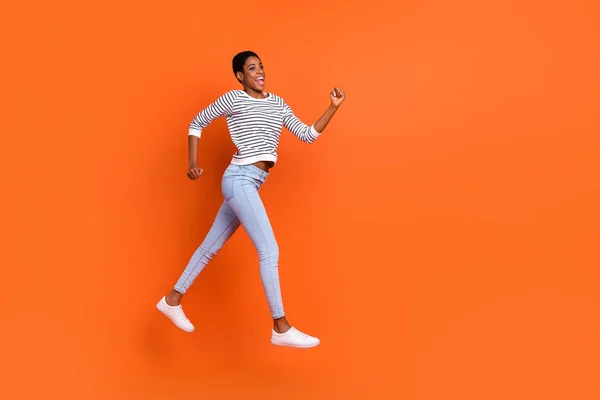 Fénykép funky rohanó harmadik nem személy viselni pulóver ugrás futó üres tér elszigetelt narancs színű háttér — Stock Fotó