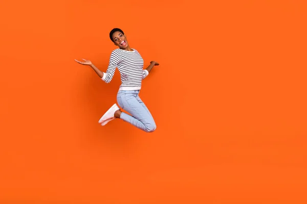Фото довольно милой буч женщина одета свитер прыгая высоко пустое пространство изолированный оранжевый цвет фона — стоковое фото