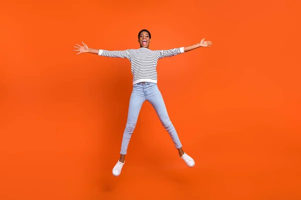 Teljes hosszúságú testméret kilátás vonzó vidám lány jumping szórakozás elszigetelt túl élénk narancs színű háttér — Stock Fotó