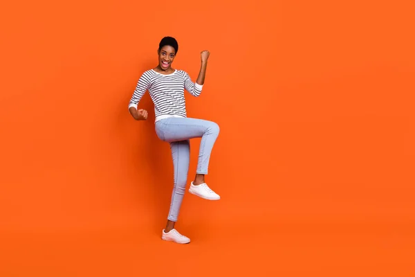 興奮幸運な3番目の性別の人の写真プルオーバーを着用上昇拳歩く空のスペース孤立オレンジ色の背景 — ストック写真
