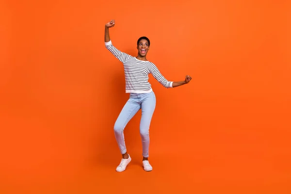 Ganzkörperfoto von niedlichen Millennial Lady Dance tragen Hemd Jeans Turnschuhe isoliert auf orangefarbenem Hintergrund — Stockfoto