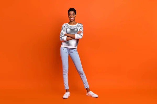 Full size photo of boss short hairstyle young guy crossed arms wear shirt jeans sneakers isolated on orange background — Stock Photo, Image