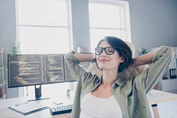 Retrato de programador de administrador de sistema feminino sonhador pacífico relaxando após dia de trabalho duro dentro de casa no escritório — Fotografia de Stock