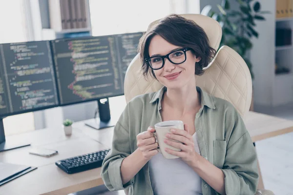Portret van aantrekkelijke zelfverzekerde geschoolde meisje expert hacker tech support manager drinken cafeïne op het werk plaats station binnen — Stockfoto