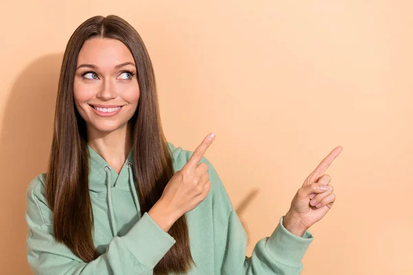 Porträtt av attraktiv glad flicka visar kopia utrymme annons idé beslut lösning isolerad över beige pastell färg bakgrund — Stockfoto