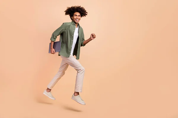 Longitud completa cuerpo tamaño vista de atractivo alegre chico saltando celebración portátil corriendo trabajo aislado en beige pastel color fondo —  Fotos de Stock