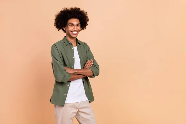 Portrait of attractive cheerful glad wavy-haired guy folded arms copy blank space isolated over beige pastel color background — Stock Photo, Image