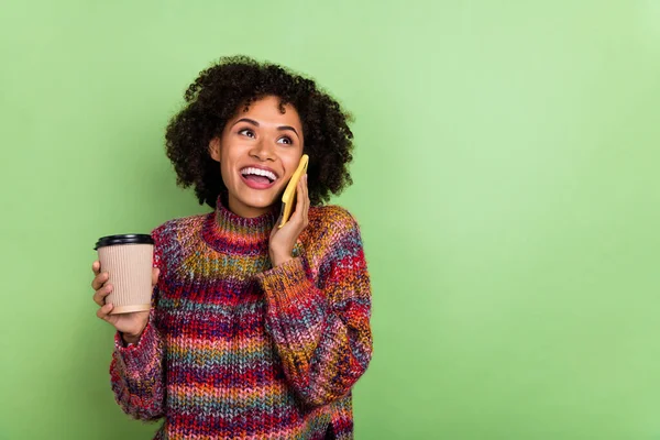 Portrait of attractive cheerful girl hold coffee speak telephone isolated on green color background — Stock Photo, Image