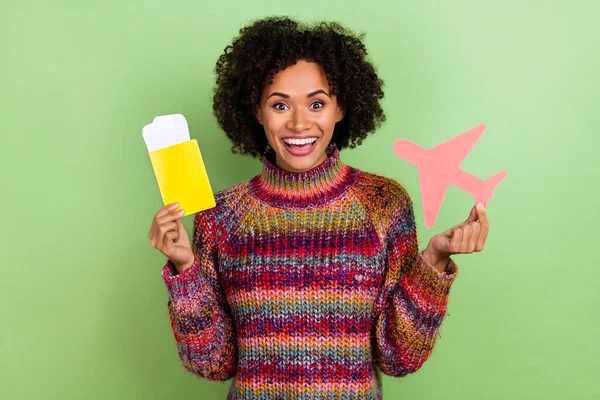 Portret van opgewonden vrolijke dame houden tickets papier vliegtuig tandenglimlach geïsoleerd op groene kleur achtergrond — Stockfoto