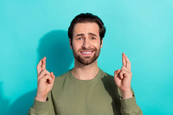 Photo de stressé brunet jeune homme croisé doigts porter chemise verte isolé sur fond de couleur sarcelle — Photo