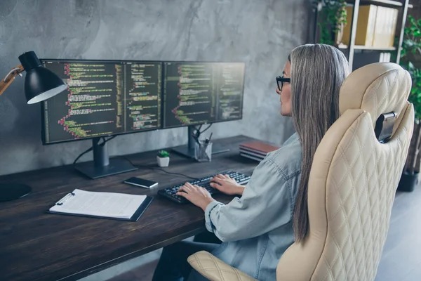 Perfil vista lateral retrato de atractiva inteligente hábil mujer de pelo gris hábil escribiendo tarea de resolución de código en la estación de trabajo en el interior —  Fotos de Stock