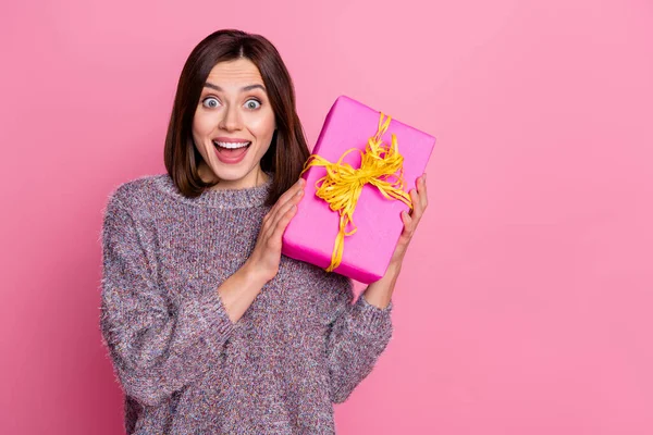 Porträtt av attraktiva förvånad glad flicka håller i händerna festlig gåva tillfälle isolerad över rosa pastell färg bakgrund — Stockfoto
