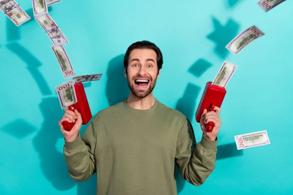 Foto van jonge opgewonden man schieten geld inkomen winst financiën voordeel geïsoleerd over turquoise kleur achtergrond — Stockfoto