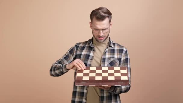 Хлопець відкрив шахову дошку вразив ізольований пастельний кольоровий фон — стокове відео