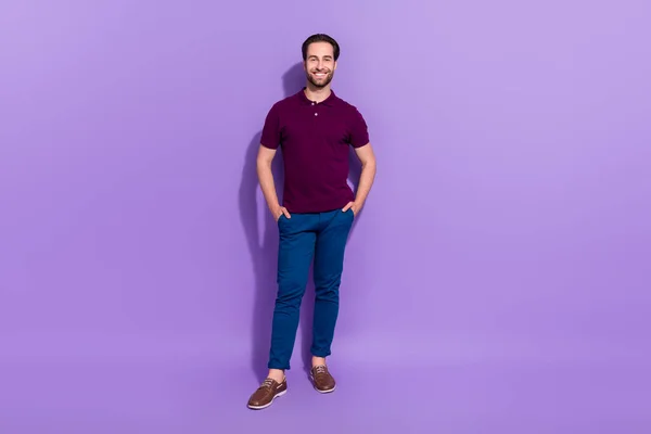 Full length photo of nice millennial brunet guy stand wear t-shirt spodnie buty izolowane na fioletowym tle — Zdjęcie stockowe