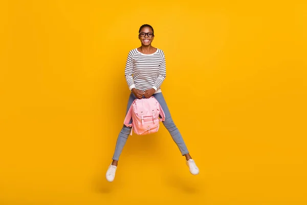 Πλήρες μέγεθος φωτογραφία του νεαρού χαρούμενο κορίτσι άλμα μέχρι κρατήστε τσάντα ταξίδι απομονωμένο πάνω από κίτρινο χρώμα φόντο — Φωτογραφία Αρχείου
