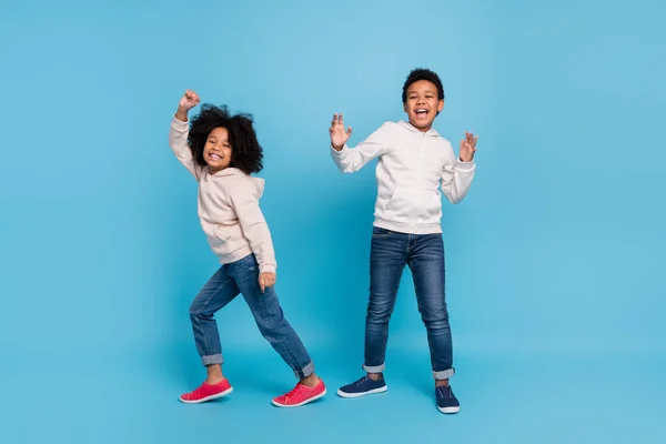 Повнометражний вигляд на тіло привабливих веселих дітей, які танцюють, рухаючись, розважаються ізольовано на яскраво-блакитному фоні — стокове фото