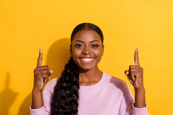 Portret van vrolijke mooie dame directe vingers boven lege ruimte banner geïsoleerd op gele kleur achtergrond — Stockfoto