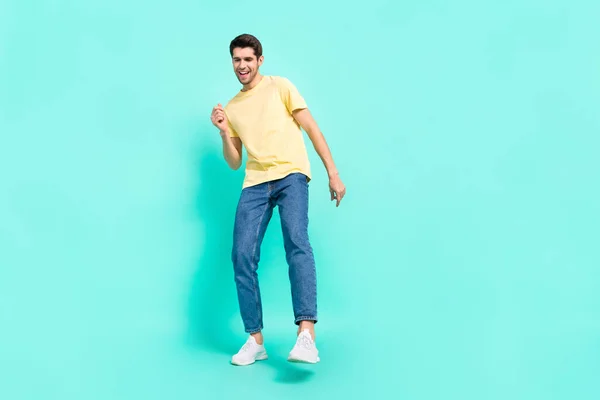 Foto de tamaño completo de lindo chico morena danza desgaste camiseta jeans zapatillas aisladas sobre fondo turquesa — Foto de Stock