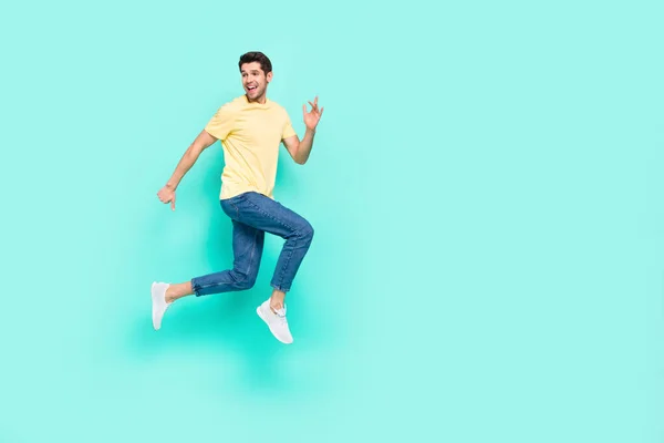 Volledige grootte profiel foto van opgewonden gek persoon rush snelheid kijken lege ruimte geïsoleerd op turquoise kleur achtergrond — Stockfoto