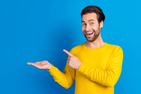 Portret van aantrekkelijke vrolijke verbaasd brunet jongen demonstreren op palm kopieerruimte bieden advertentie geïsoleerd over helder blauwe kleur achtergrond — Stockfoto