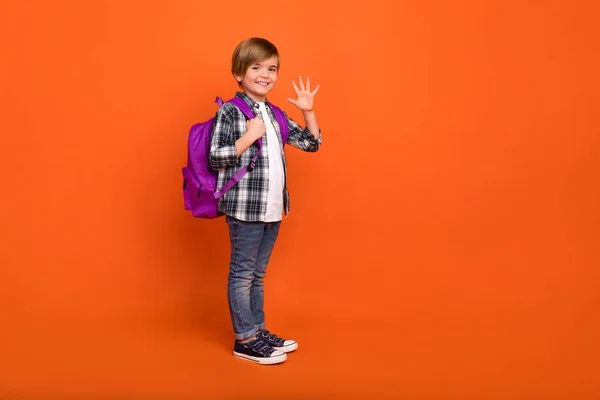 Full size profiel zijkant foto van jeugd vrolijke jongen golf hi les geïsoleerd over oranje kleur achtergrond — Stockfoto